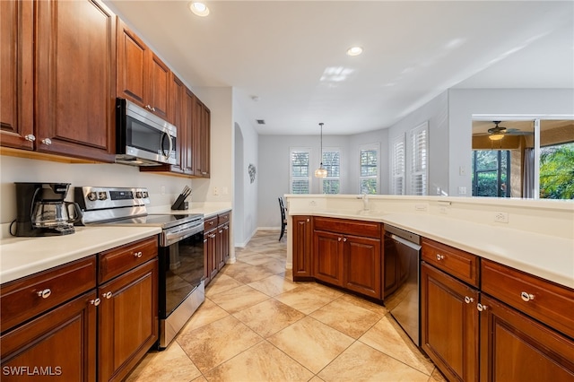 kitchen with hanging light fixtures, light tile patterned floors, stainless steel appliances, and sink