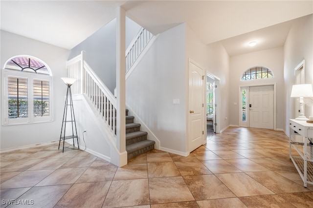 tiled foyer entrance featuring a towering ceiling