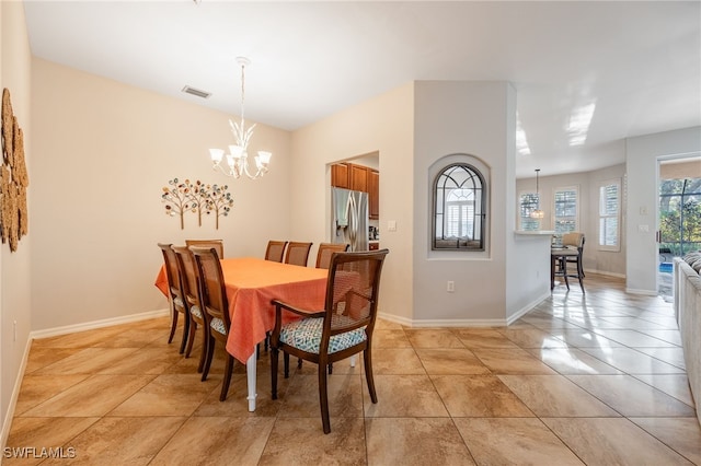 tiled dining room with an inviting chandelier