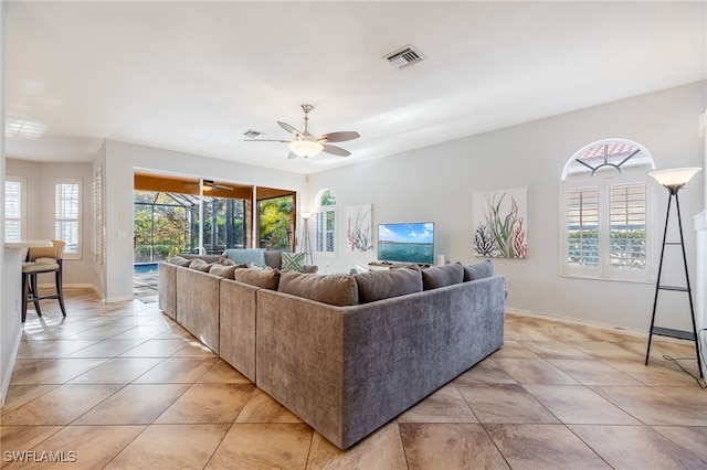 living room featuring light tile patterned flooring, plenty of natural light, and ceiling fan