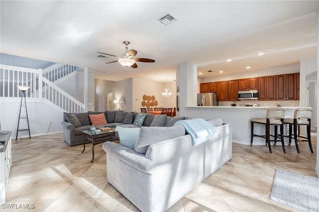 living room with ceiling fan with notable chandelier