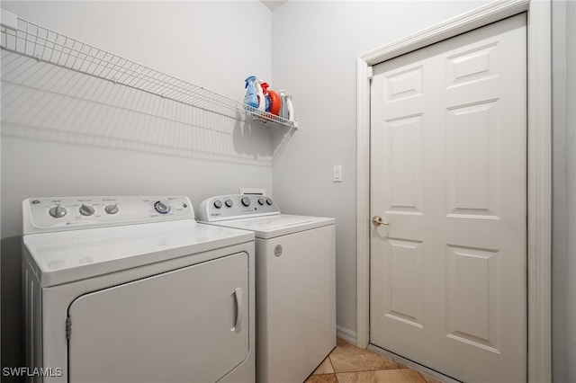 laundry area with washer and dryer and light tile patterned flooring