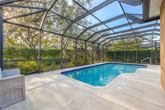 view of swimming pool featuring a lanai and a patio area