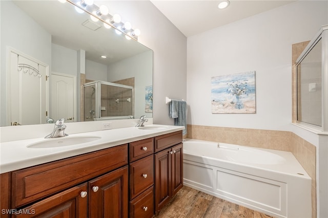 bathroom featuring vanity, plus walk in shower, and wood-type flooring