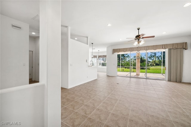 unfurnished living room with recessed lighting, visible vents, baseboards, ceiling fan with notable chandelier, and light tile patterned flooring