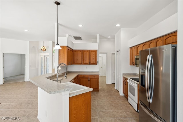 kitchen with stainless steel appliances, a peninsula, a sink, light countertops, and brown cabinetry