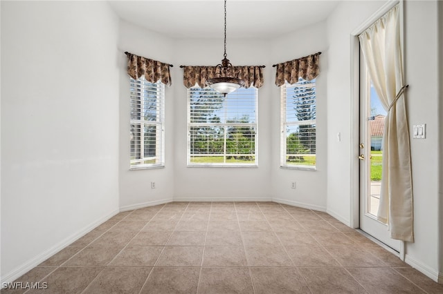 unfurnished dining area with tile patterned flooring and baseboards