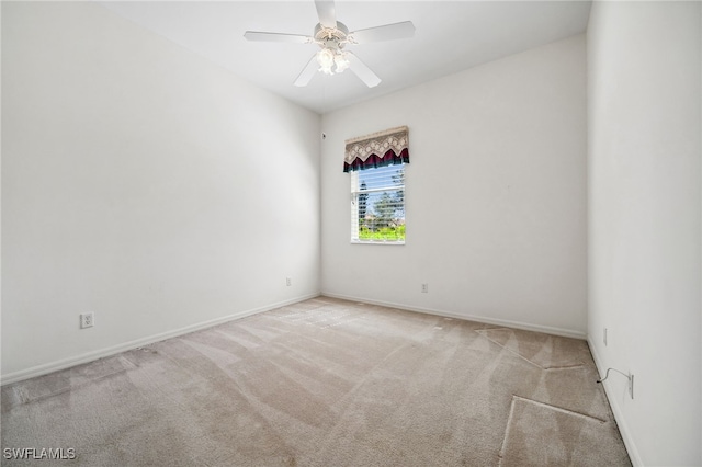 carpeted empty room with ceiling fan and baseboards