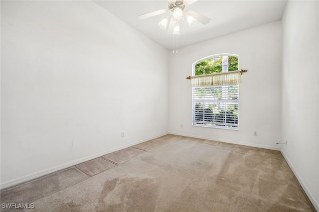 spare room with carpet floors, baseboards, and a ceiling fan