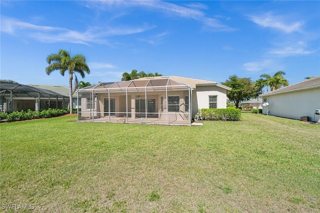 back of property with glass enclosure, a tile roof, a patio area, and a yard