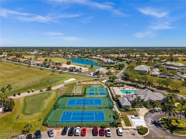 birds eye view of property with view of golf course and a water view