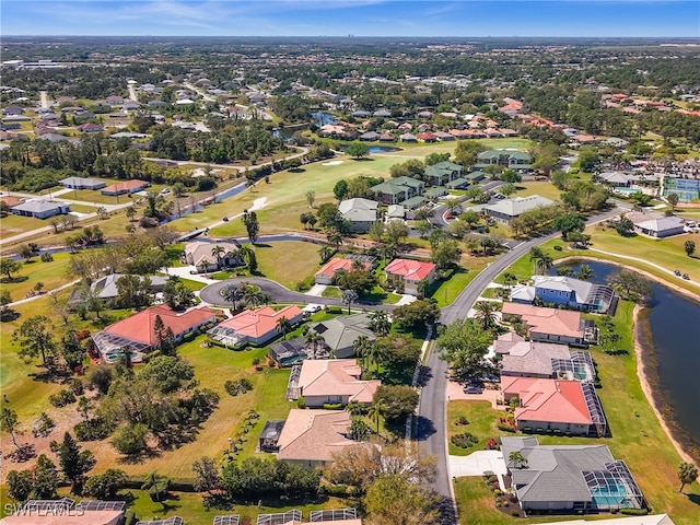 aerial view featuring golf course view, a water view, and a residential view