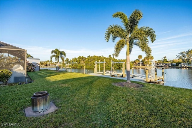 view of yard featuring a water view, a dock, and glass enclosure