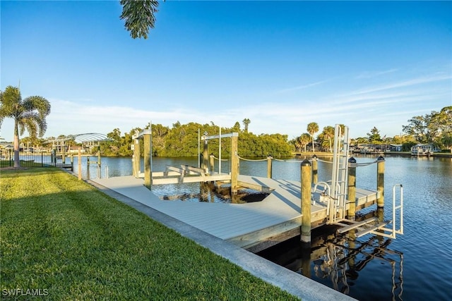 dock area with a water view, boat lift, and a lawn