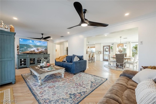 living room featuring crown molding, ceiling fan, and light parquet floors