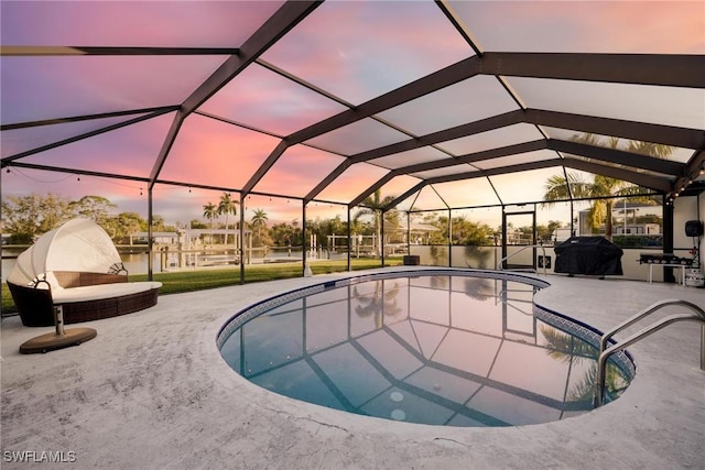 outdoor pool with glass enclosure, area for grilling, and a patio