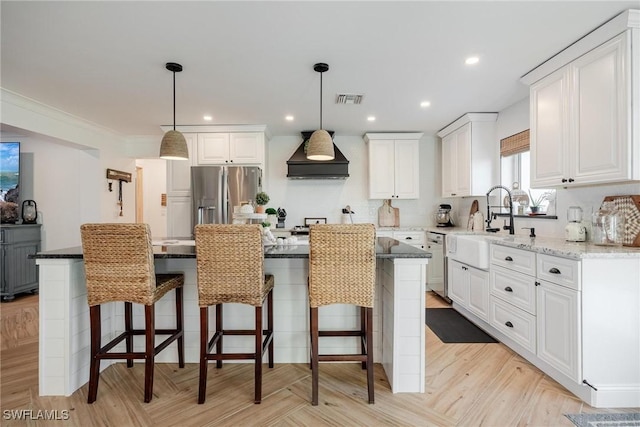 kitchen with custom range hood, stainless steel appliances, a center island, and white cabinets