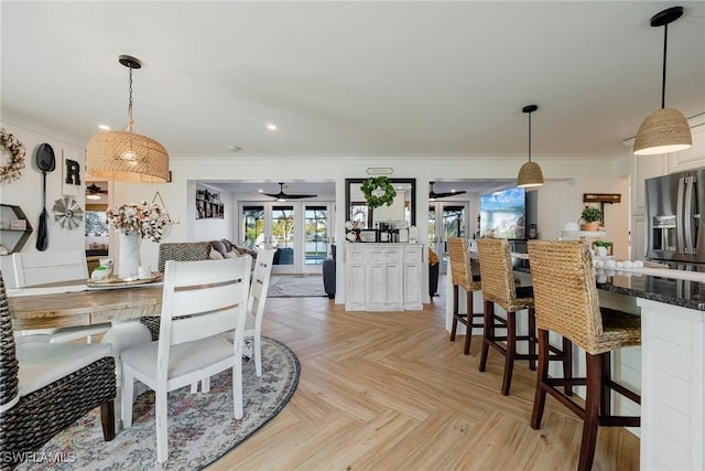 dining room with light parquet flooring, ceiling fan, crown molding, and french doors