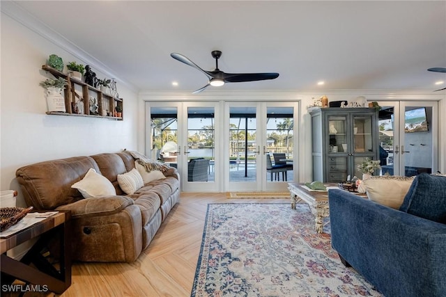 living room with french doors, light parquet flooring, ornamental molding, and ceiling fan