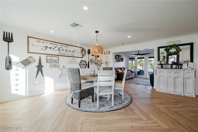 dining area featuring light parquet flooring, crown molding, and french doors