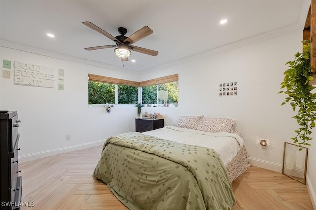 bedroom with light parquet floors, ornamental molding, and ceiling fan