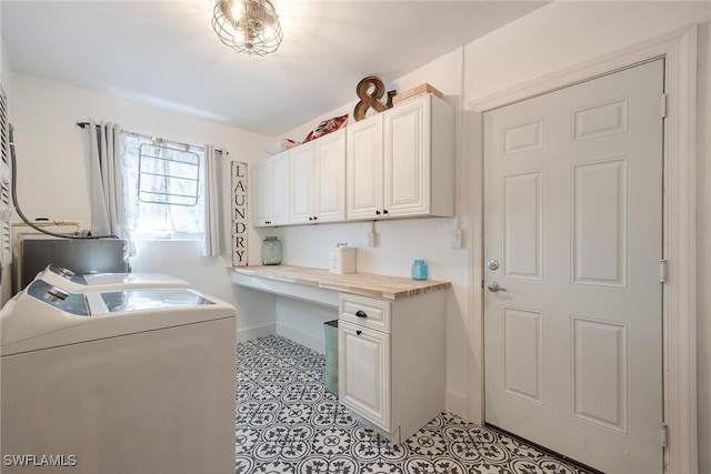 clothes washing area with cabinets, light tile patterned flooring, and washer and clothes dryer