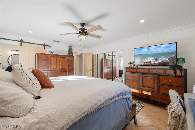 bedroom with ceiling fan, crown molding, a barn door, and light parquet flooring