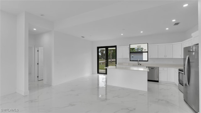 kitchen with white cabinetry, sink, a center island, and appliances with stainless steel finishes