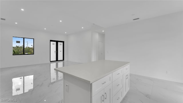 kitchen featuring white cabinetry, a center island, and french doors