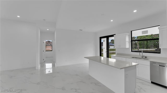 kitchen with white cabinetry, stainless steel dishwasher, a center island, and sink