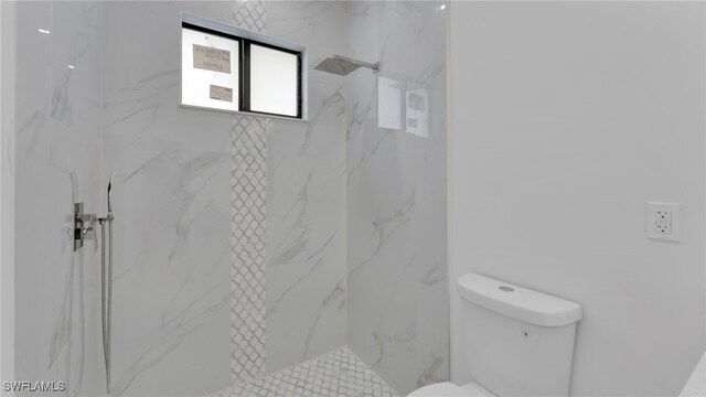 bathroom featuring toilet and tiled shower