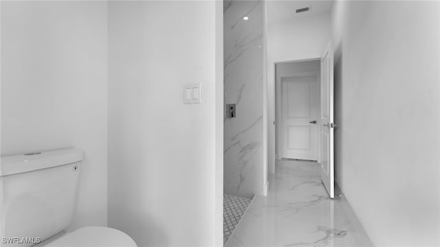 bathroom featuring walk in shower and toilet