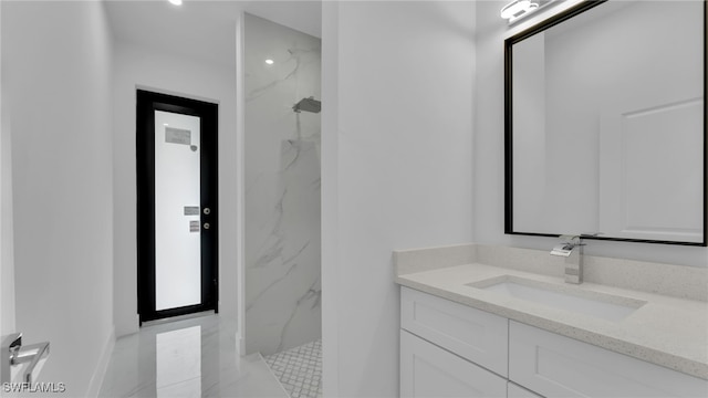 bathroom with vanity and a tile shower