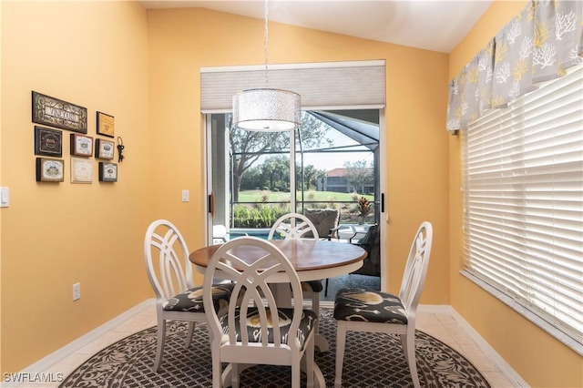 tiled dining space with lofted ceiling