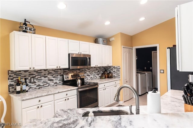 kitchen with white cabinetry, independent washer and dryer, and stainless steel appliances