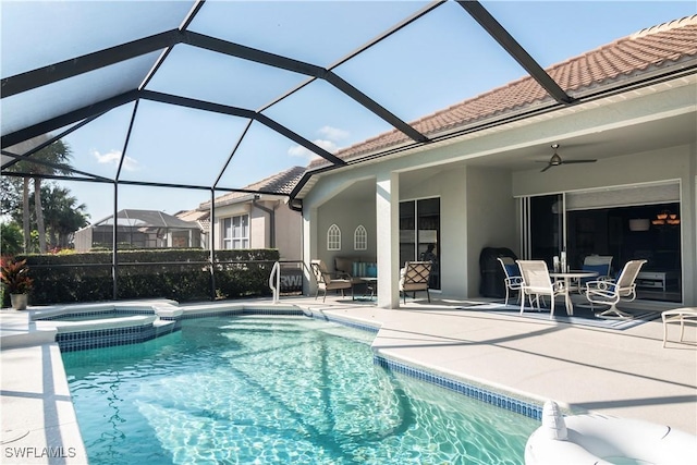 view of pool with an in ground hot tub, a lanai, ceiling fan, and a patio