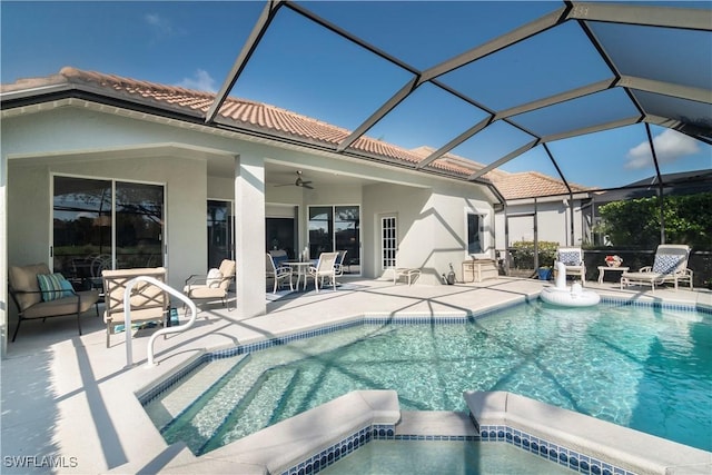 view of swimming pool featuring ceiling fan, an in ground hot tub, glass enclosure, and a patio area