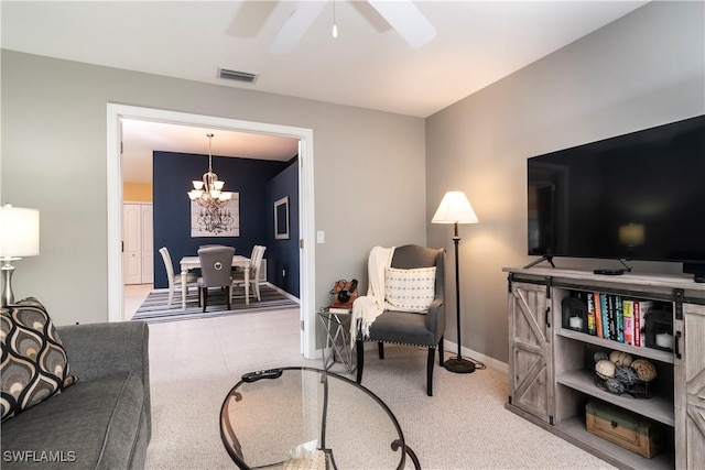 carpeted living room with ceiling fan with notable chandelier