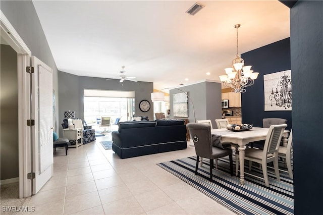 tiled dining area with ceiling fan with notable chandelier