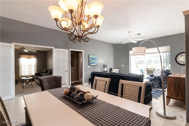 tiled dining area with ceiling fan with notable chandelier