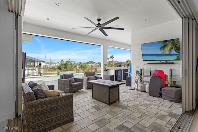 view of patio with ceiling fan and an outdoor living space with a fire pit