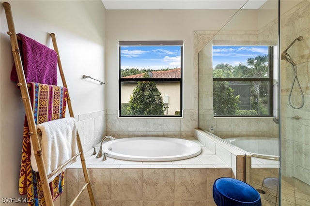 bathroom with shower with separate bathtub and plenty of natural light