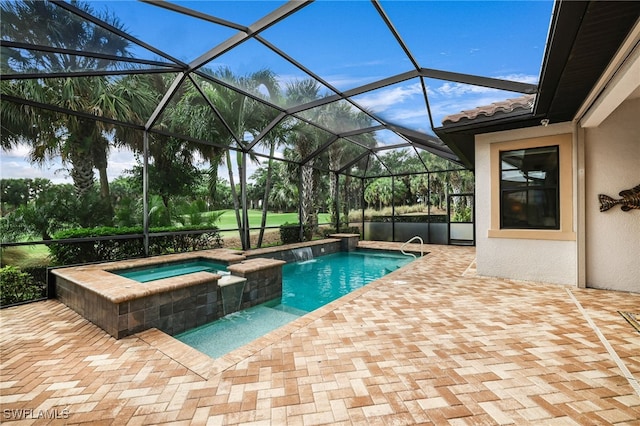 view of pool featuring a patio area, pool water feature, glass enclosure, and an in ground hot tub