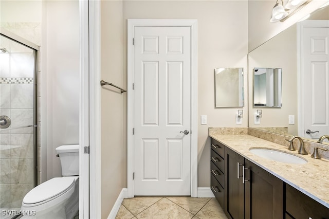 bathroom featuring vanity, a shower with shower door, tile patterned floors, and toilet