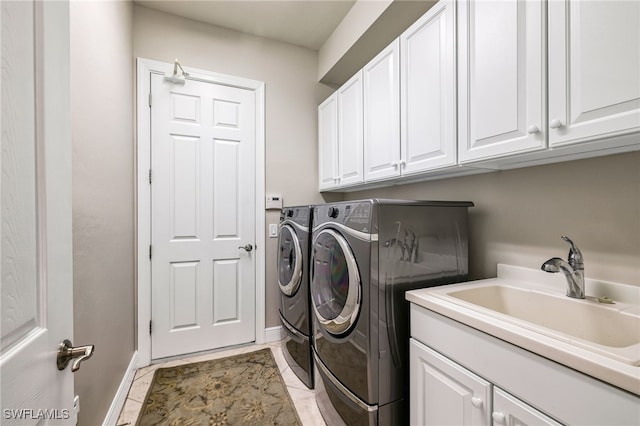 clothes washing area featuring cabinets, separate washer and dryer, sink, and light tile patterned floors