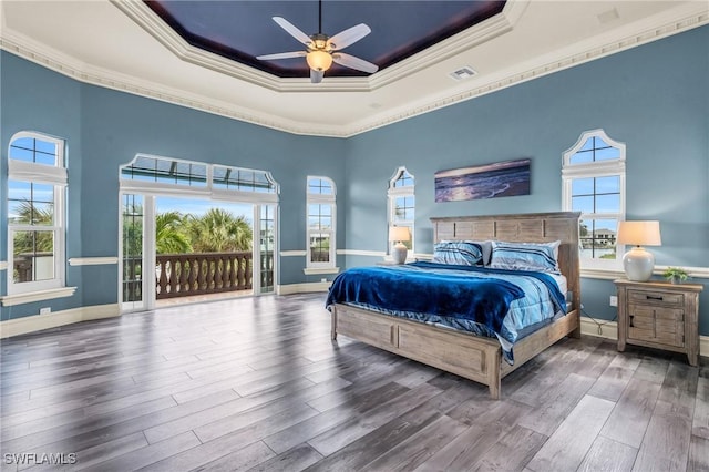 bedroom featuring crown molding, a raised ceiling, and access to outside