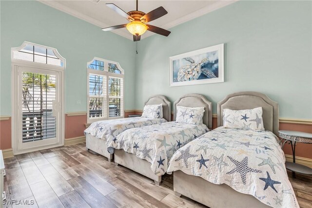 bedroom with hardwood / wood-style flooring, crown molding, and ceiling fan