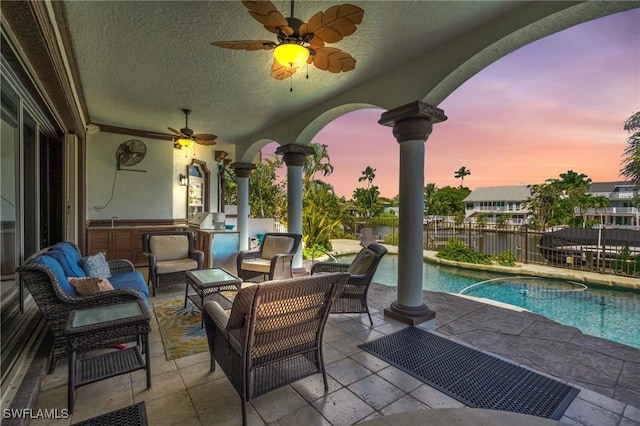 view of patio / terrace featuring outdoor lounge area, fence, a ceiling fan, exterior kitchen, and a fenced in pool