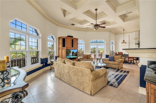 living room with coffered ceiling, light tile patterned floors, ornamental molding, beam ceiling, and a high ceiling