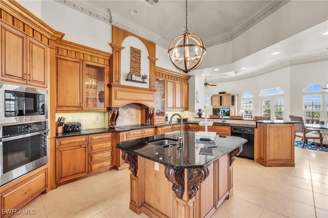 kitchen featuring sink, a kitchen breakfast bar, kitchen peninsula, an island with sink, and black appliances